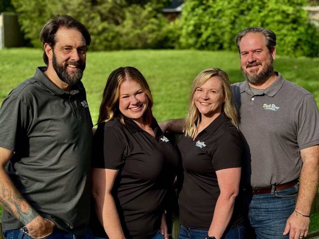 Four Duck River Plumbing team members on the lawn