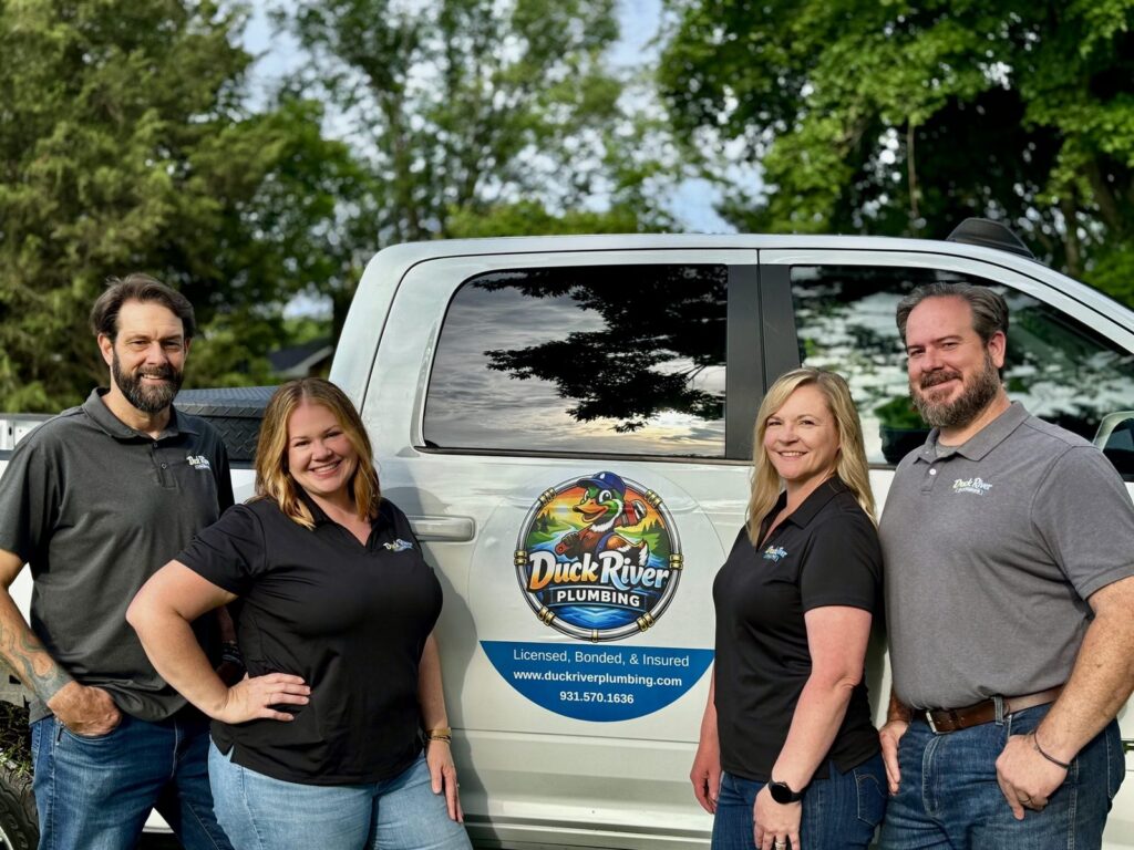 The Duck River Plumbing team beside their branded work truck in Columbia, TN